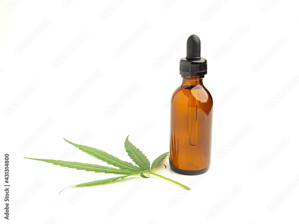 A bottle of cannabis oil extracts and green marijuana leaves isolated on a white background. Medical cannabis concept A bottle of cannabis oil extracts and green marijuana leaves isolated on a white background. Medical cannabis concept