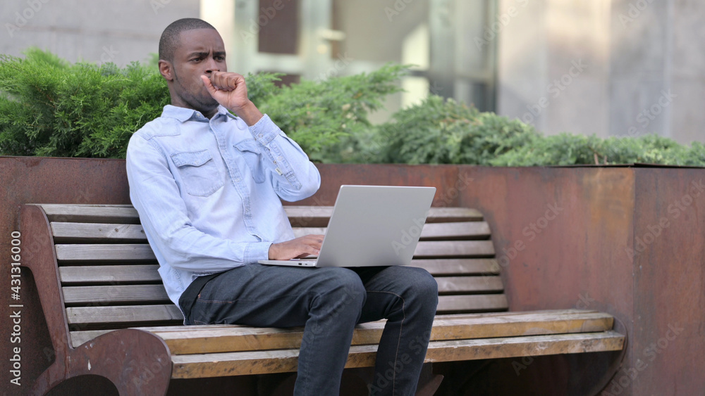 Sick Young African Man using Laptop Coughing Outdoor Sick Young African Man using Laptop Coughing Outdoor