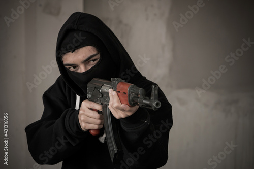 Terrorist hold a pistol gun aiming eye contact with blurred background.