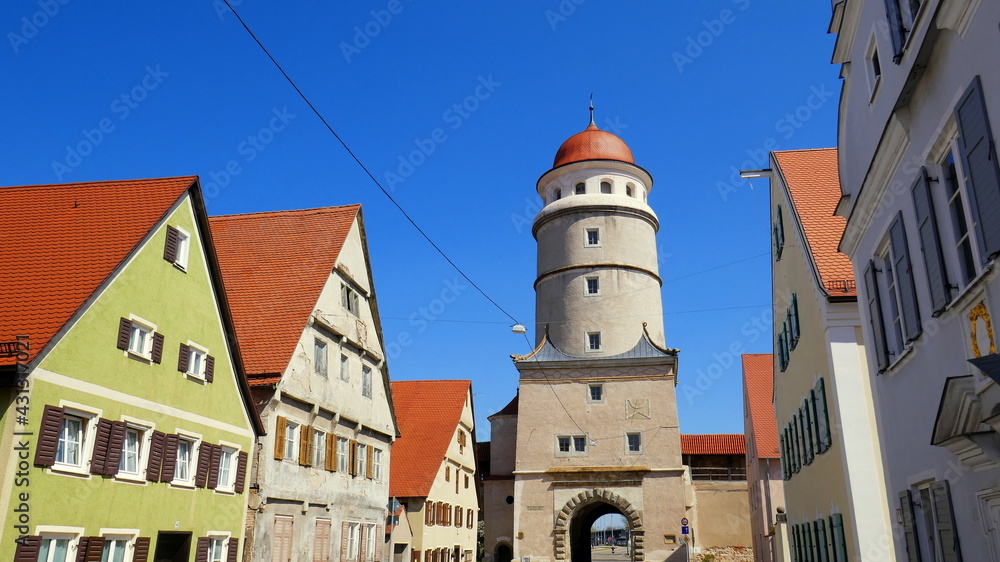 Stadtansicht von Nördlingen mit Löpsinger Tor und Stadtmauer mit Giebelhäusern unter blauem Himmel