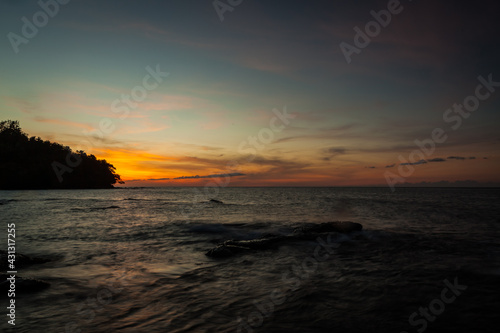 Vivid sunset sky waterscape and silhouette forest island © Juhku