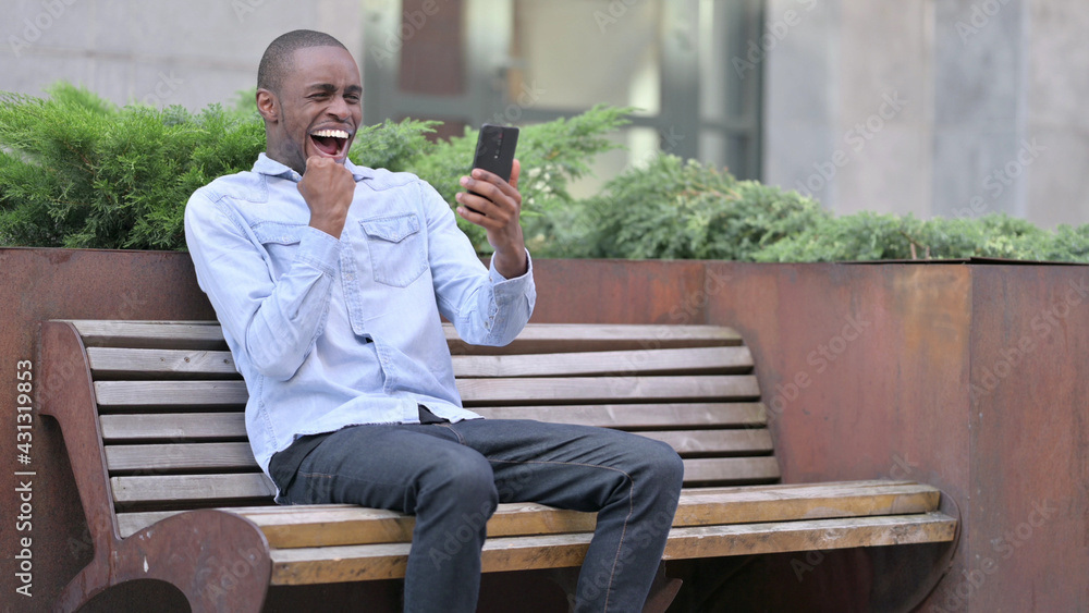 Ambitious African Man Celebrating Success on Smart Phone Ambitious African Man Celebrating Success on Smart Phone