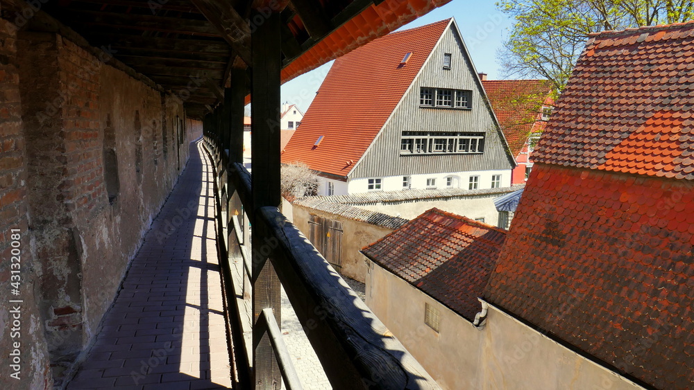 Aussicht von Stadtmauer in Nördlingen auf die Altstadt mit alten Häusern bei blauem Himmel Aussicht von Stadtmauer in Nördlingen auf die Altstadt mit alten Häusern bei blauem Himmel