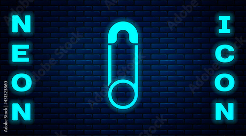 Glowing neon Classic closed steel safety pin icon isolated on brick wall background. Vector