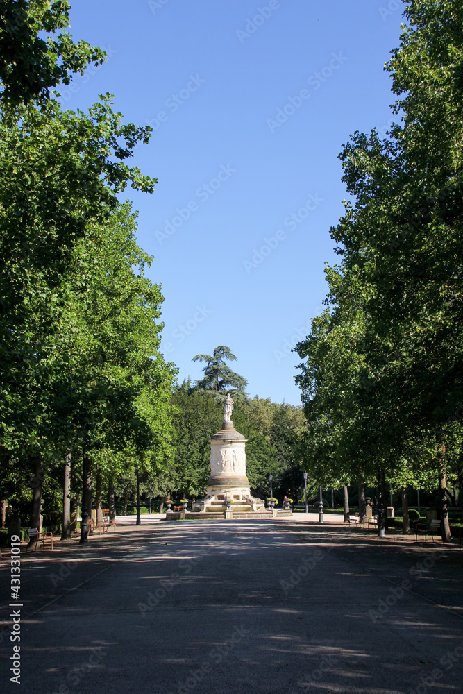 Interior of a Pamplona park with trees around and a statue in the background