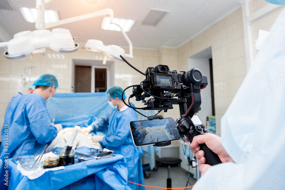 The videographer shoot the surgeon and assistants in the operating room with surgical equipment The videographer shoot the surgeon and assistants in the operating room with surgical equipment