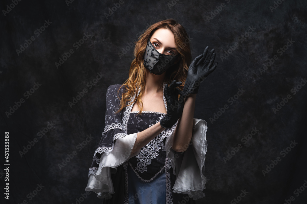 Fototapeta premium Beautiful woman in renaissance dress, face mask and gloves on abstract dark background, coronavirus, covid-19 protection concept