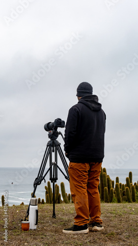 Surf photographer waiting for the waves with his camera, thermos of hot water and Argentine mate
 photo