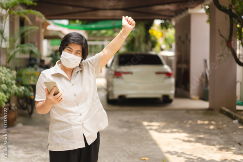 Happy asian elderly woman quarantine at home use mask protect for corona virus at home.
