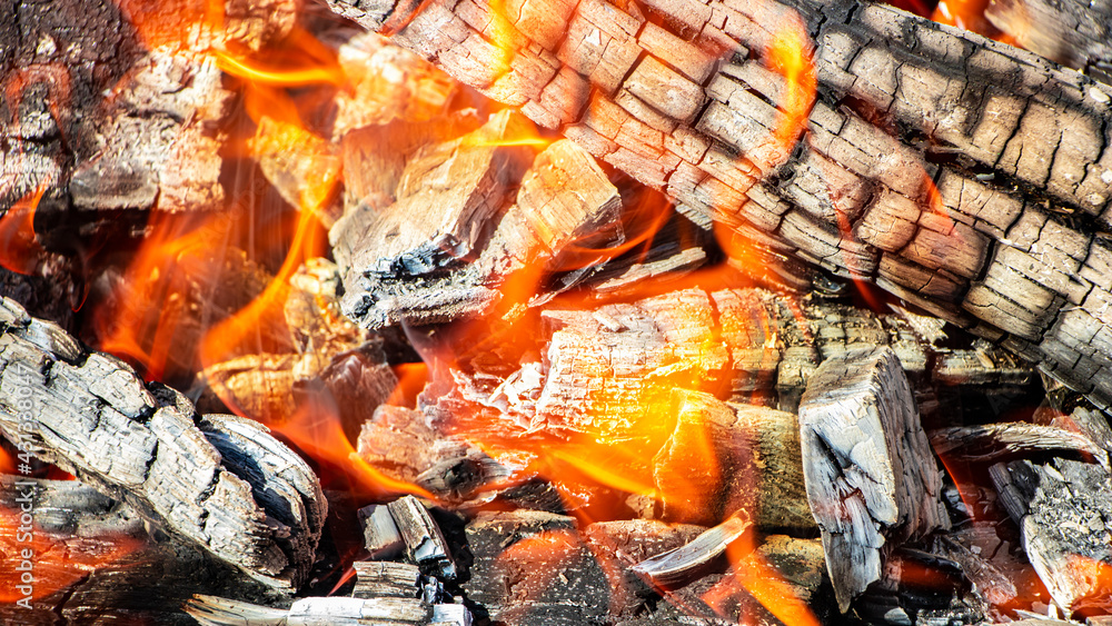 Burning firewood and coals in the grill. Close-up. Macro shooting. Burning fire. Grilling meat. Coals for frying