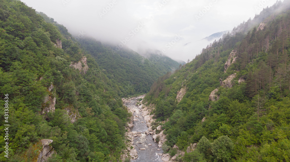 River stream on a green valley in an amazing and peaceful national park with fog and cloudy. Rural scenery mount and canyon in the balkan