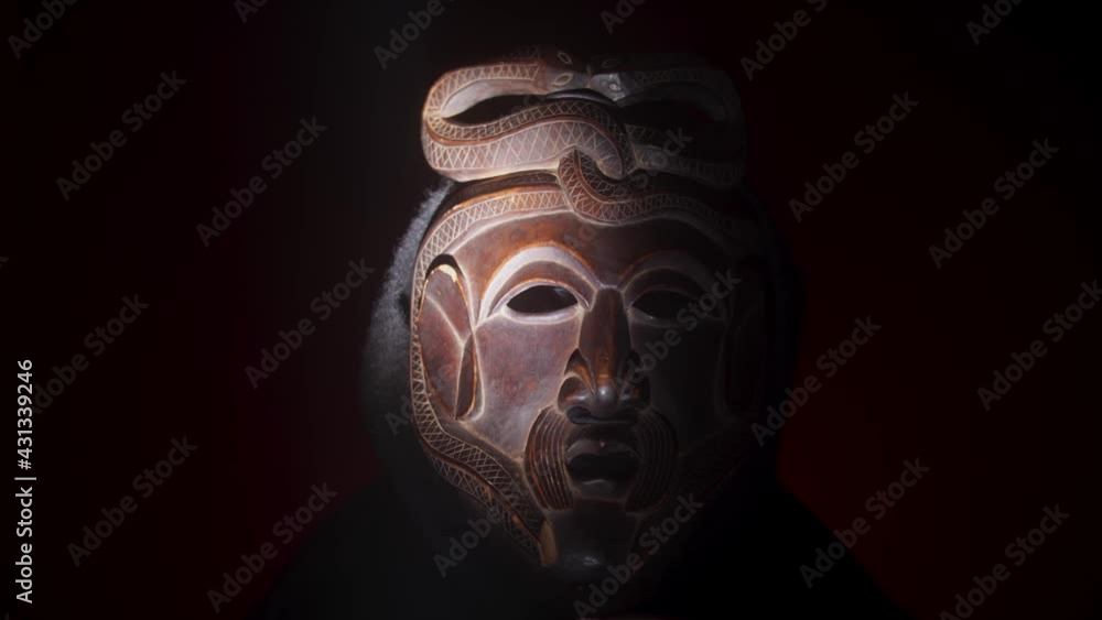 Creepy, masked cultist standing in a dark room. Scary horror scene