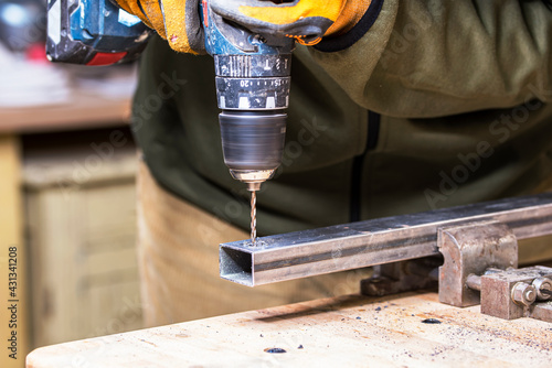 Mecanicien drilling a hole inside the metal bar. photo