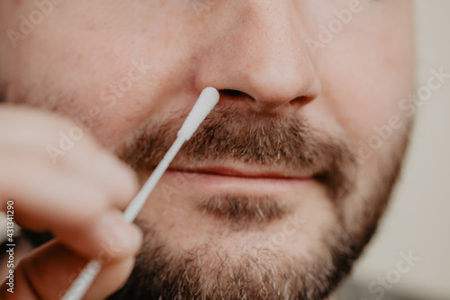Mann f  hrt Corona Selbsttest mit Testst  bchen in der Nase durch