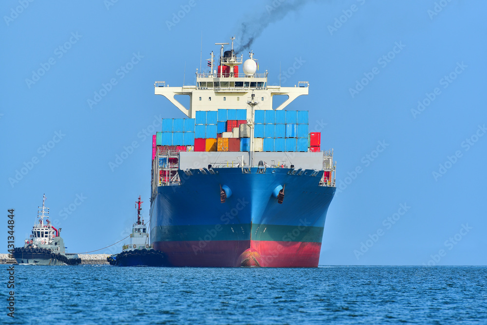A modern blue container ship moving in calm water, Cargo ship bulbous bow view Cargo ship with tug boat in sea freight, Shipping.