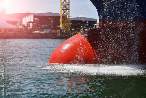 Bulging bow of a ship at sea with depth markings and anti-fouling lines on the hull. Usually bulging bows are located at or under the waterline and thus increase speed and fuel efficiency. photo