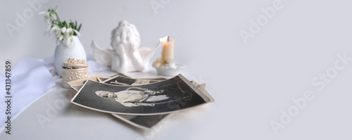 stack of vintage photos, baby photography of 1960, candle is lit, first spring flowers, snowdrop, Galanthus in vase, concept of family tree, genealogy, childhood memories