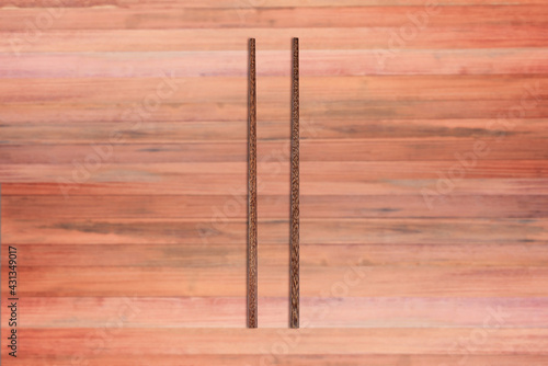 Top view of wooden chopsticks on wooden background.