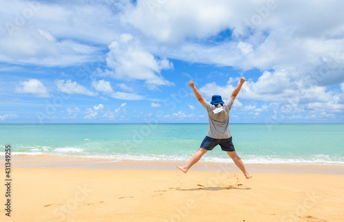 Excited energetic happy tourist man hang face masks and jumping at the beach