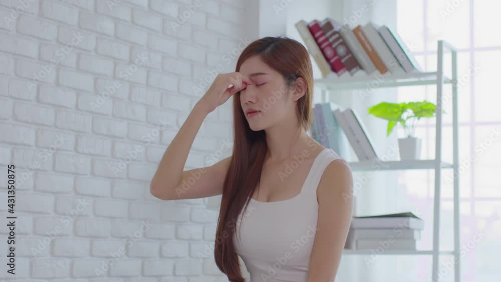 Asian young Woman has a Migraine and headache after wake up in cozy bedroom at home,Suddenly of painful attack on head massage around on pain spot,Healthcare Concept Asian young Woman has a Migraine and headache after wake up in cozy bedroom at home,Suddenly of painful attack on head massage around on pain spot,Healthcare Concept