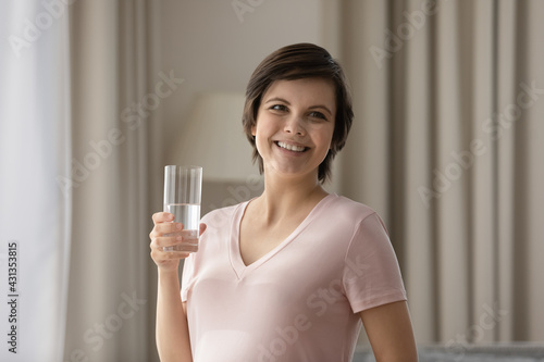 Smiling Caucasian pregnant woman enjoy clean pure still mineral water, feel dehydrated thirsty at home. Happy millennial female follow healthy lifestyle during pregnancy. Diet, hydration concept.