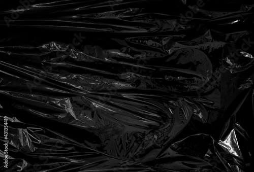a transparent plastic wrap on black background. realistic plastic wrap texture for overlay and effect. wrinkled plastic pattern for creative and decorative design.