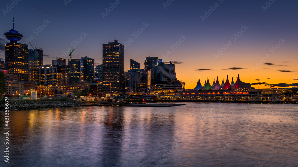 Obraz premium Sunset over the Harbor and the Sails of Canada Place, the Cruise Ship Terminal and Convention Center on the Waterfront of Vancouver, British Columbia, Canada