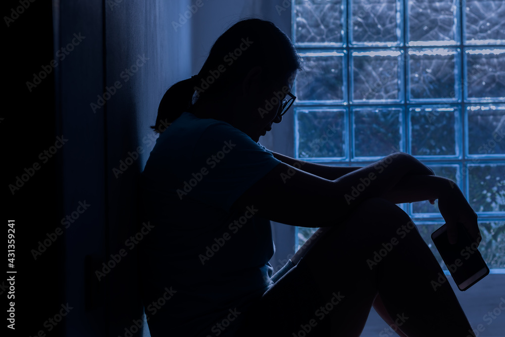 Silhouette depress woman sitting and hold smartphone in hand. Silhouette depress woman sitting and hold smartphone in hand.