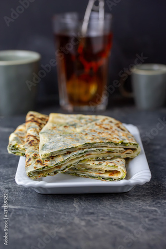 Traditional Turkish food gözleme with cheese and spinach. Turkish pancake gozleme concept on the dark background.
