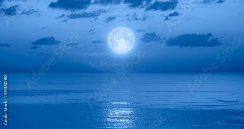 Fototapeta Naklejka Na Ścianę i Meble -  Full moon rising over empty ocean at night 