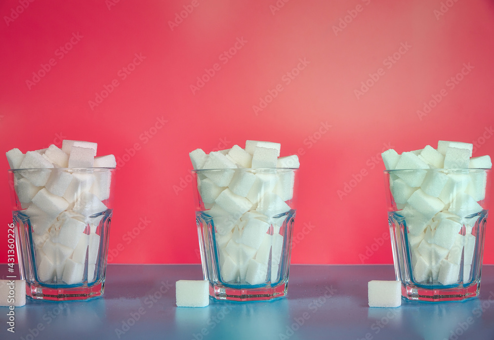 Three Glasses full with sugar cubes on pink background, sugar,unhealthy,sweets,junk food concept background retro modern design Three Glasses full with sugar cubes on pink background, sugar,unhealthy,sweets,junk food concept background retro modern design