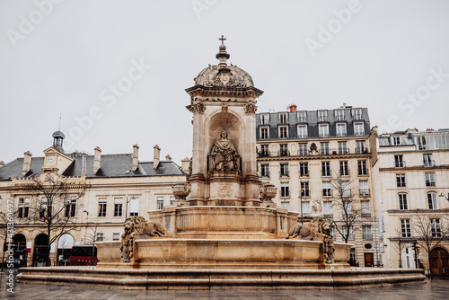 Roman Catholic Church of Saint-Sulpice in Paris, France. Cathedral was founded in 1646. Square with fountain in front of facade. Sculptures of saints and lions adorn fountain.