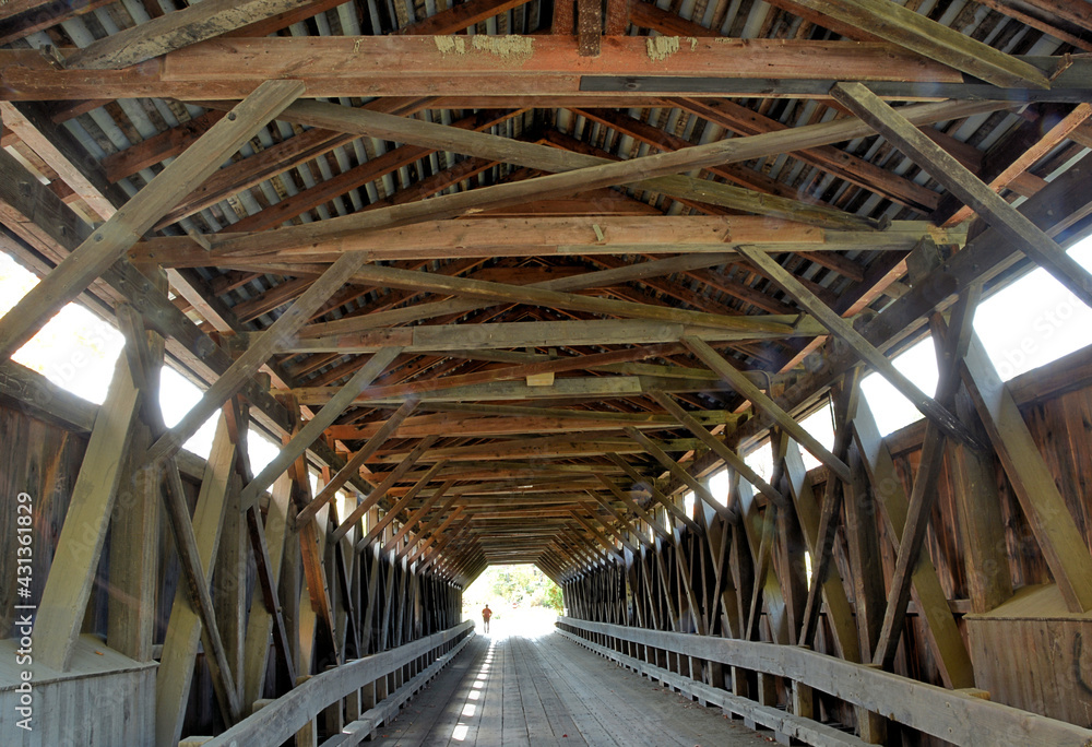 Interior construction of old 19th century wooden covered bridge spanning Wild Ammonoosuc River in Bath, New Hampshire. Built in 1849, this covered bridge is registered as a U.S. historic landmark.