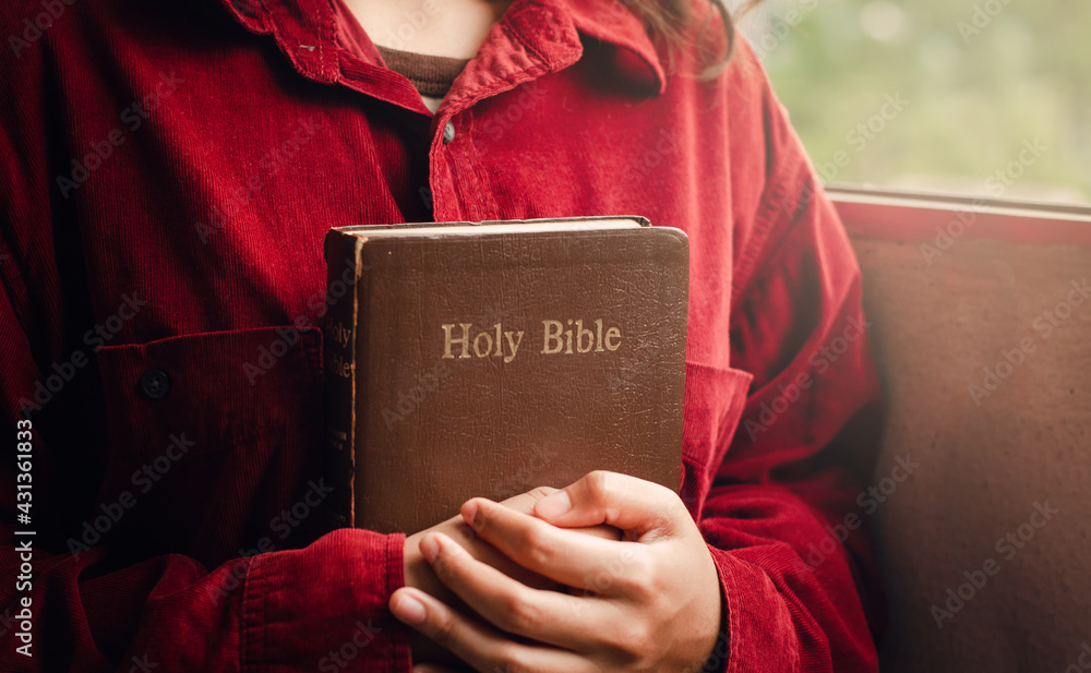 A teenage girl wearing a red blouse is praying for a blessing from God ...