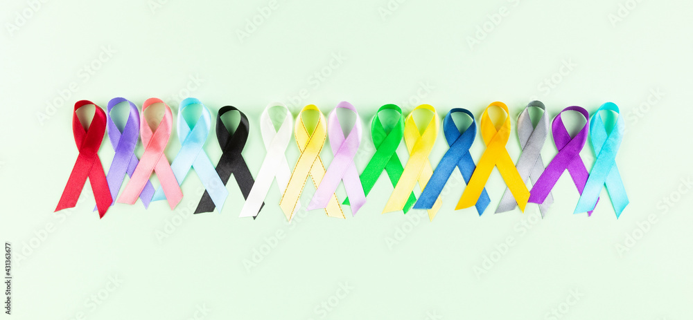 World cancer day background. Colorful ribbons, cancer awareness. Green background. Top view