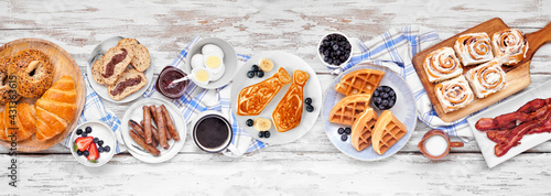 Fathers Day brunch table scene. Overhead view on a white wood banner background. Tie pancakes, mustache toast and an assortment of dad themed food. © Jenifoto