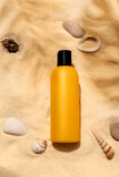 Bottle of sunscreen lotion on the sandy beach. Skin care and protection concept. Golden tan.