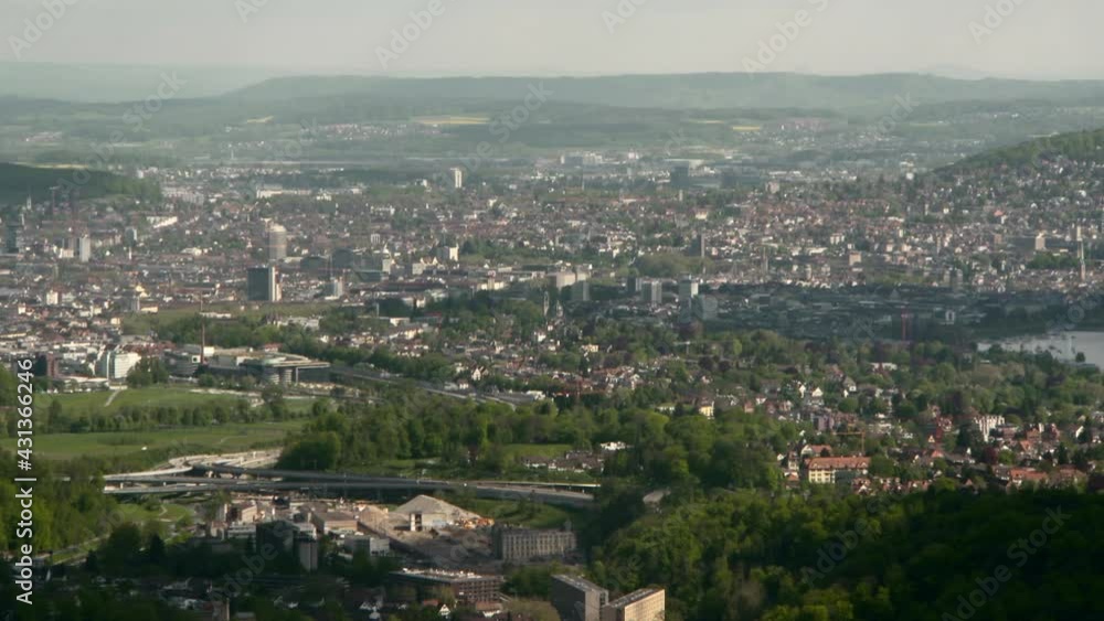 Panning Zurich, The Surrounding Area, And Zurichsee Lake From High Atop A Hill, With Hazy Skies, Trees, And Rolling Hills Stretching To The Horizon Panning Zurich, The Surrounding Area, And Zurichsee Lake From High Atop A Hill, With Hazy Skies, Trees, And Rolling Hills Stretching To The Horizon