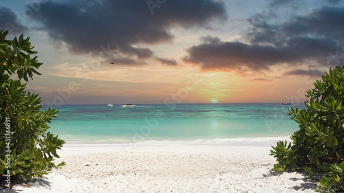 empty beach with clear water and blue sky in summer at sunset