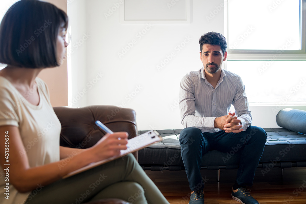 Obraz premium Psychologist taking notes during therapy session.