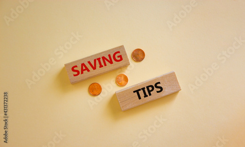 Saving tips symbol. Wooden blocks with words 'saving tips' on beautiful white background. Metallic coins. Business and saving tips concept. Copy space.