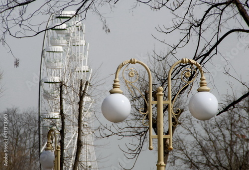 Electric street lamp exclusive shape, metal and glass, close-up against a blue cloudy sky