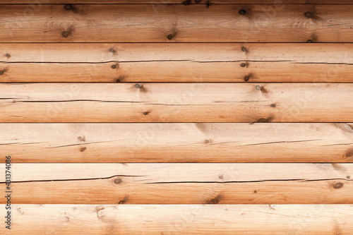 Wooden wall made of uncolored logs, background texture
