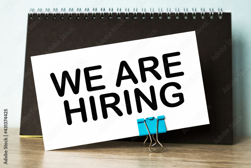 Business concept. List with text sheet WE ARE HIRING of paper for notes Business concept. List with text sheet WE ARE HIRING of paper for notes