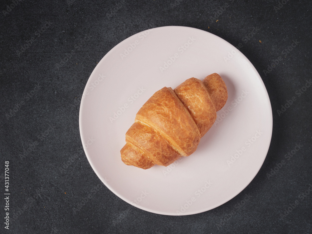 baked french croissants on a brown kitchen board, black background, close-up baked french croissants on a brown kitchen board, black background, close-up