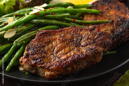 Grilled pork loin chops served with French green beans salad and beer