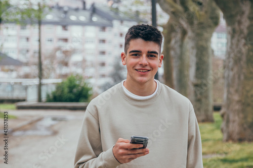 young male teenager on the street looking at the mobile phone