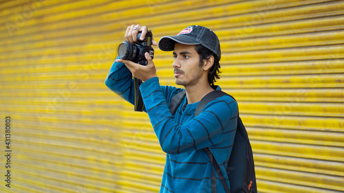 Photography Young Indian photographer taking pictures on colour background
