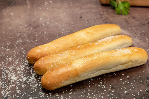 Breadsticks with sea salt being sprinkled on top