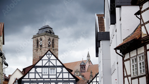 Gotische Stadtkirche in der Altstadt von Bad Hersfeld mit Fachwerkhäusern und wolkigem Himmel photo